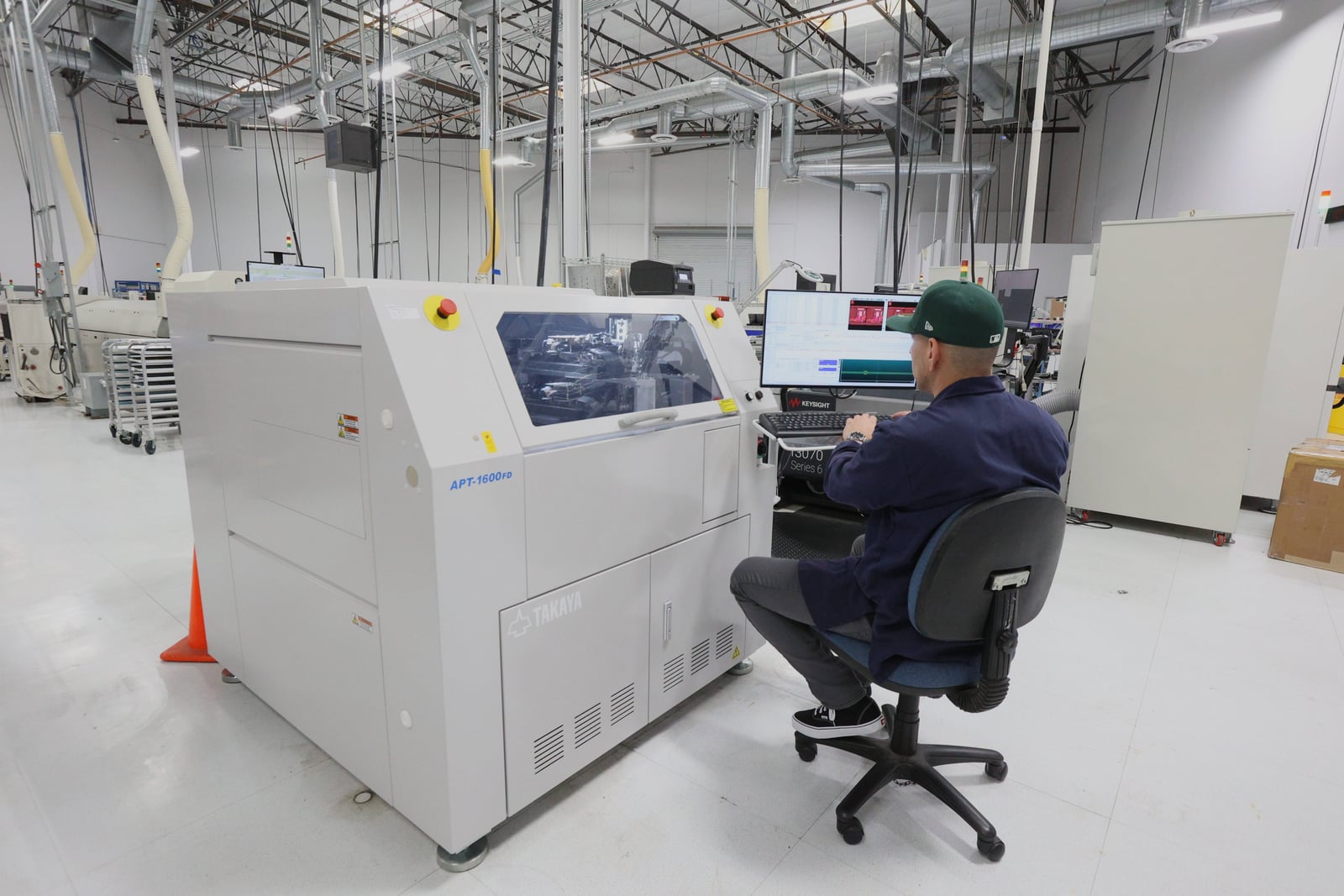 Technician operating the TAKAYA APT-1600FD flying-probe tester